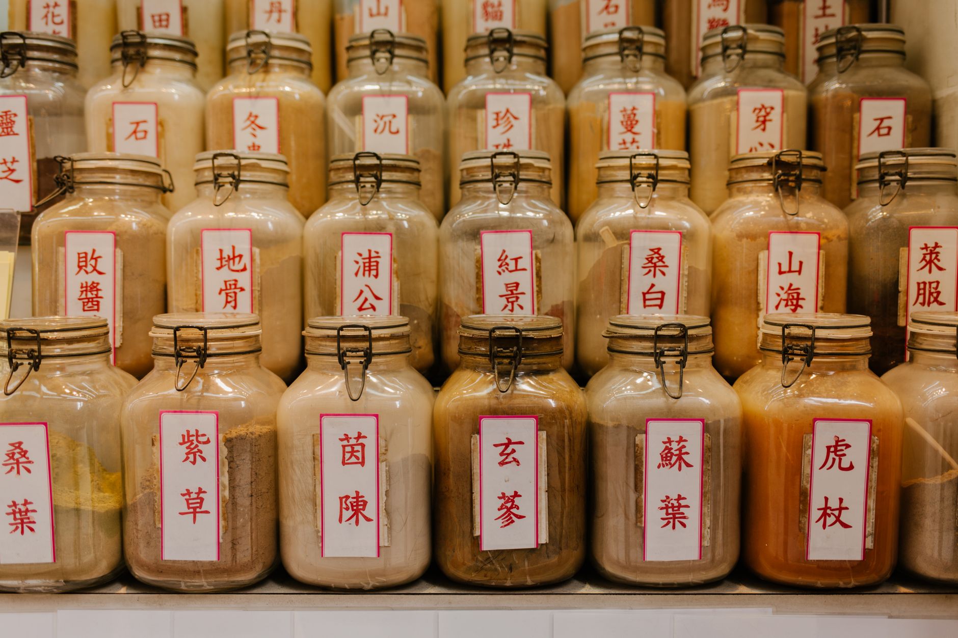 Traditional Chinese Medicine history – wooden jars lining a dimly lit apothecary shop interior.