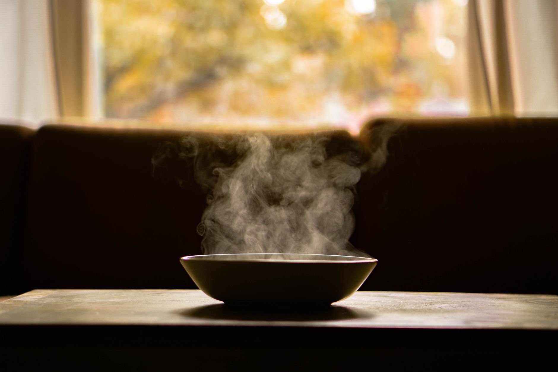 TCM food energetics – steaming bowl of herbal soup in a cozy kitchen.