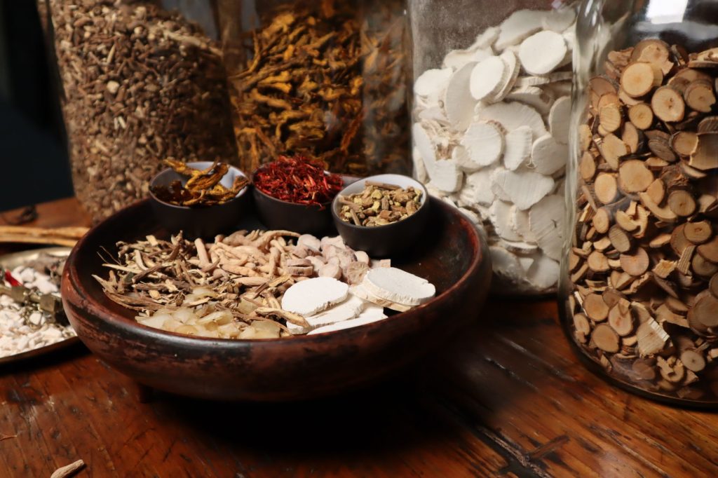 Traditional Chinese Medicine daily habits – herbs and tea on a wooden table.