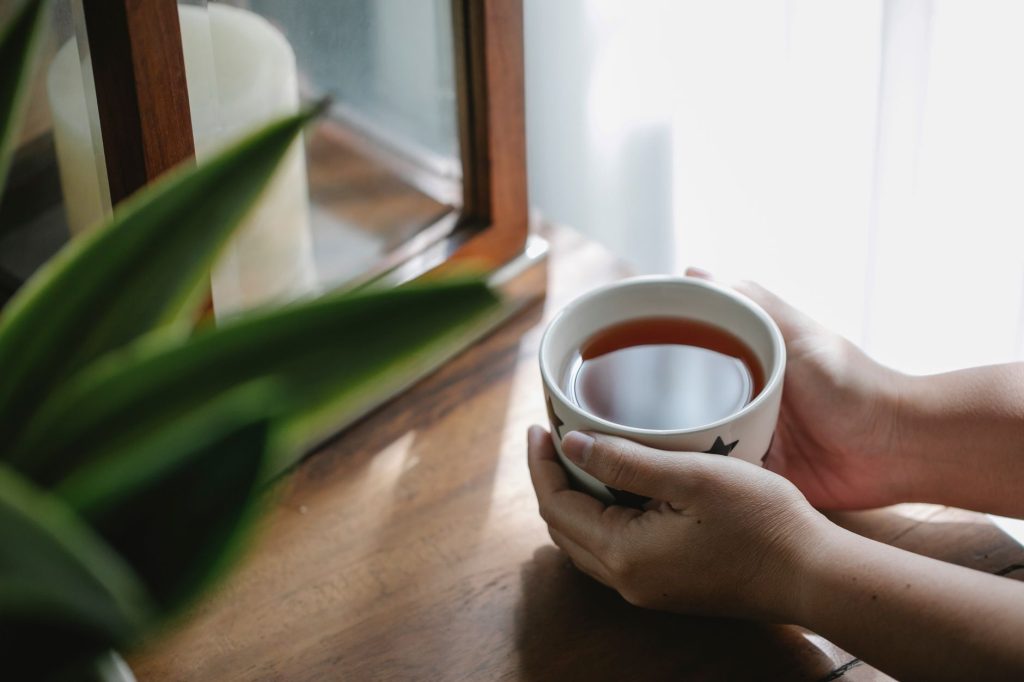 warm water TCM – person drinking warm water from ceramic cup