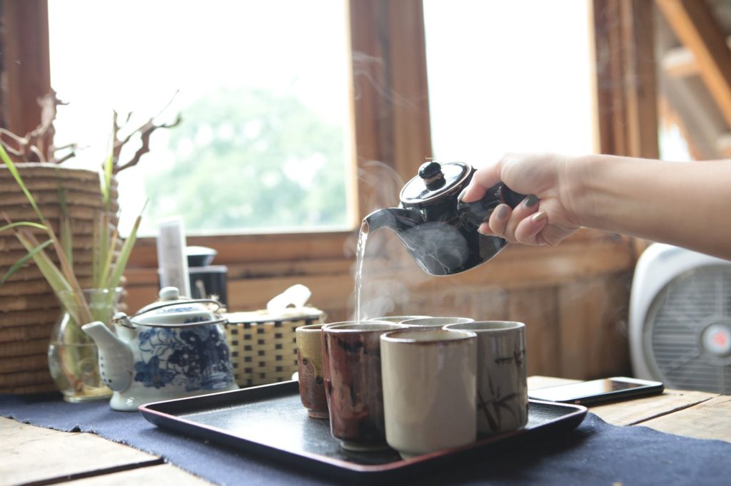 chrysanthemum tea – steaming cup on a wooden table