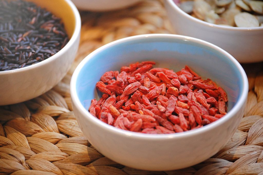 goji berries Chinese – dried red berries in a wooden bowl